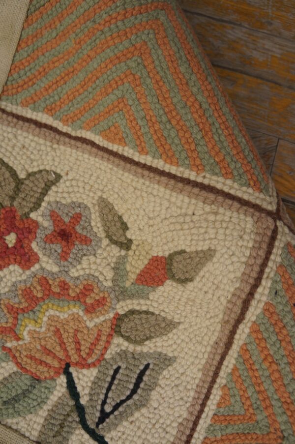 Textured rug featuring cream floral and green/orange geometric patterns, displayed on distressed yellow wooden flooring.