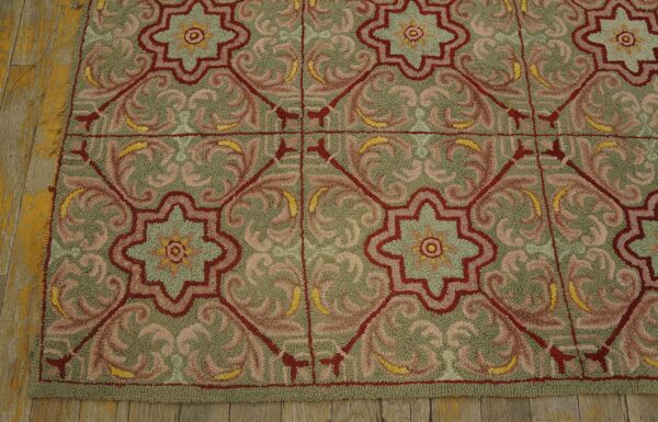 Looped pile rug with an ornate red, green, and pink geometric tile pattern rests on weathered wood planks.