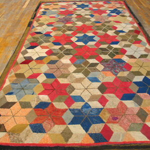 Low-pile rug with a complex red, blue, green, and beige geometric star pattern on wood floor.