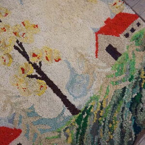 Textured high-pile rug depicting a red-roofed house, a green hillside, and a yellow flowering tree.