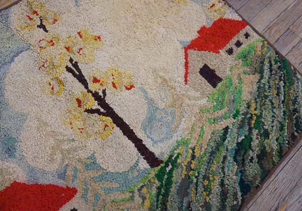 Textured high-pile rug depicting a red-roofed house, a green hillside, and a yellow flowering tree.