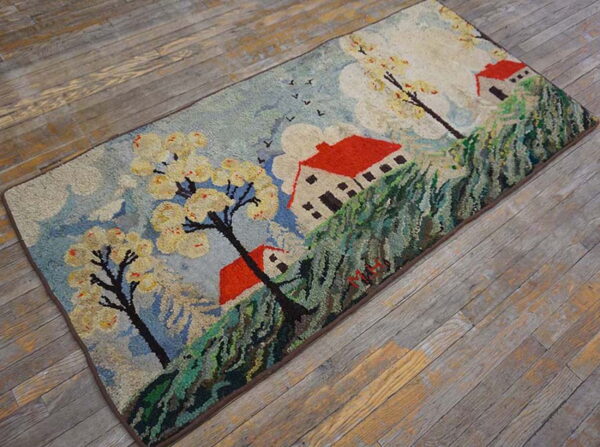 A vibrant scenic rug depicting red-roofed houses, blooming trees, and blue sky on weathered wood planks.