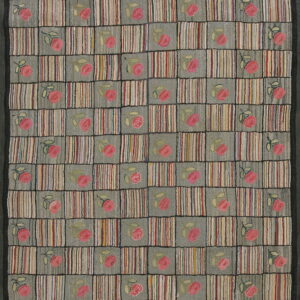 Textured rug displaying a checkerboard pattern of multicolored vertical stripes and pink roses on gray squares.