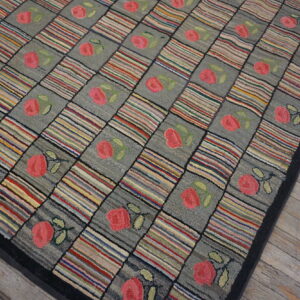 Multicolored striped and gray floral squares form a checkerboard rug on distressed gray wood flooring.