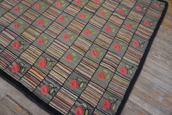 Multicolored striped and gray floral squares form a checkerboard rug on distressed gray wood flooring.