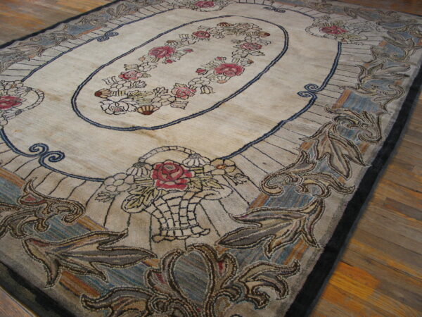 Beige and muted blue floral rug featuring a central rose garland oval on wooden plank flooring.