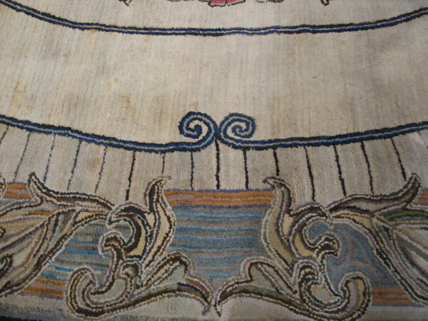 Close-up showing a cream rug with navy lines, scrolls, and multicolored botanical scrollwork at the bottom.