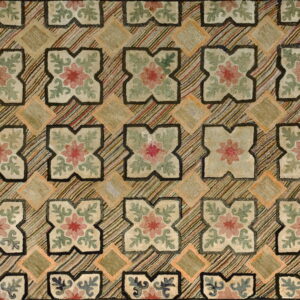 Muted beige, pink, and sage green rug with repeating floral motifs separated by multi-colored diagonal stripes.