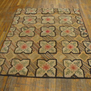 Chunky looped rug with quatrefoil floral designs and striped diamonds on worn, golden hardwood floors.