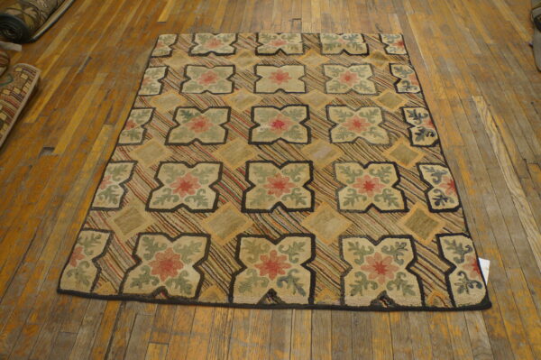 Chunky looped rug with quatrefoil floral designs and striped diamonds on worn, golden hardwood floors.