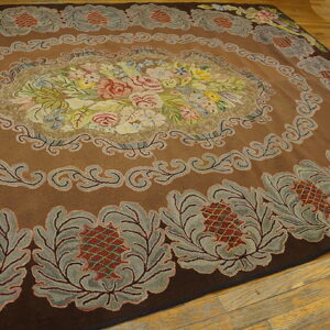 Plush brown rug featuring an elaborate multicolored floral center and gray botanical border on wood.