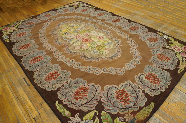 Brown high-pile rug with a multicolored floral medallion and stylized gray borders, set on wood flooring.