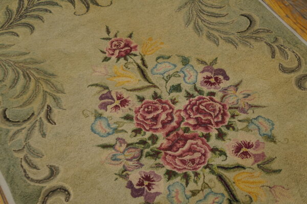 A hooked rug detail shows a central bouquet of pink, purple, and yellow flowers on a pale green ground.