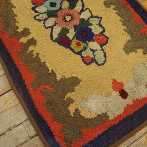 A high-texture rug featuring a gold field, multicolor floral center, and wide borders rests on distressed wood planks.