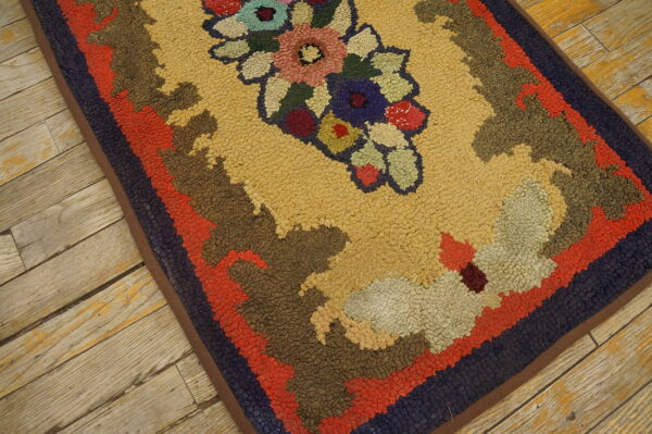 A high-texture rug featuring a gold field, multicolor floral center, and wide borders rests on distressed wood planks.