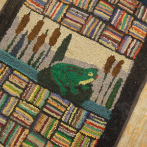 Textured rug with a green frog and cattails design framed by multicolored striped blocks on a wood floor.