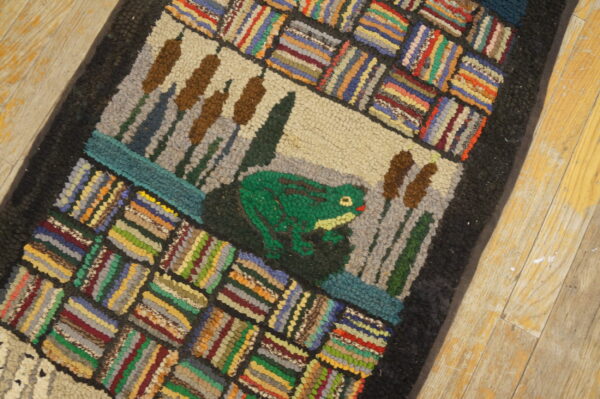 Textured rug with a green frog and cattails design framed by multicolored striped blocks on a wood floor.