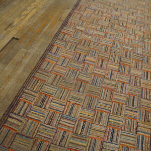 Multicolored textured runner featuring a basketweave pattern of woven stripes on aged wood planks.