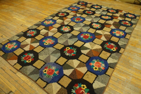 A multicolored hooked rug featuring a geometric pattern of floral octagons and segmented diamond shapes on a wood floor.