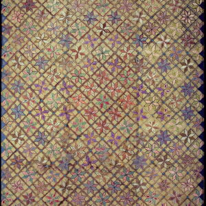 A tan rug field features a dense diamond trellis enclosing vibrant multicolored geometric floral motifs and a dark blue border.