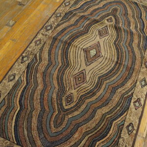 Brown, blue, and tan abstract runner rug with diamond accents placed on distressed wood flooring.