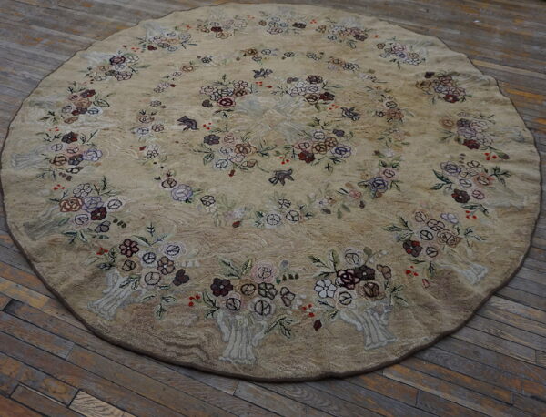 Textured beige round rug with colorful floral bouquets and bird motifs rests on distressed wooden floorboards.