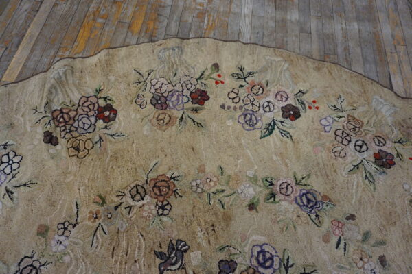 Textured beige rug with multi-colored floral pattern sits on distressed wooden floorboards.