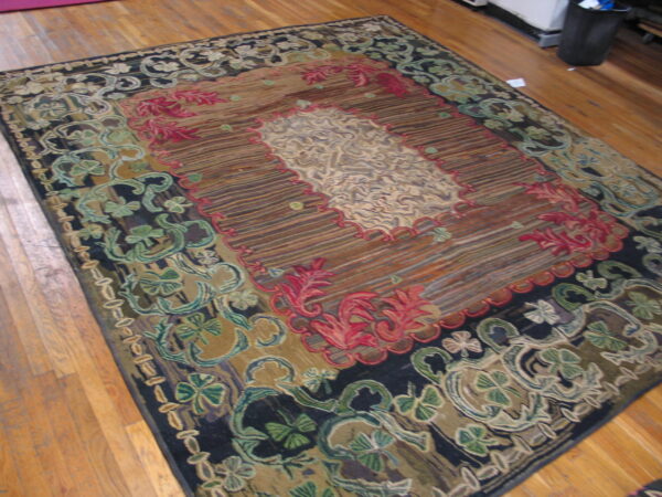 Ornate tapestry-style rug in brown, red, olive, and cream floral patterns lies on light hardwood planks.