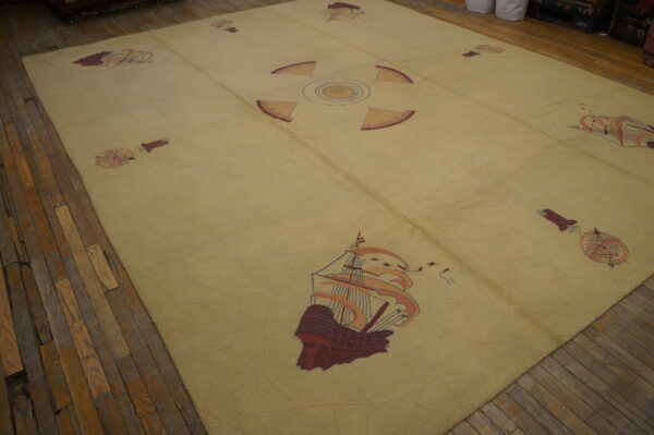 Large light yellow rug featuring nautical ship and compass patterns on distressed wood floors.