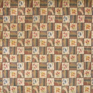 Muted earth tones and blue cover this patchwork rug featuring alternating floral and geometric squares.