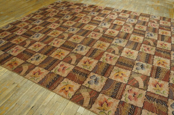 Earthy toned patchwork rug with floral and abstract squares resting on worn light wooden floorboards.