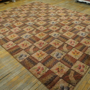 Earth-toned rug featuring a patchwork diamond pattern of florals and geometric textures on worn wood planks.