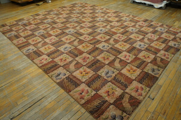 Earth-toned rug featuring a patchwork diamond pattern of florals and geometric textures on worn wood planks.