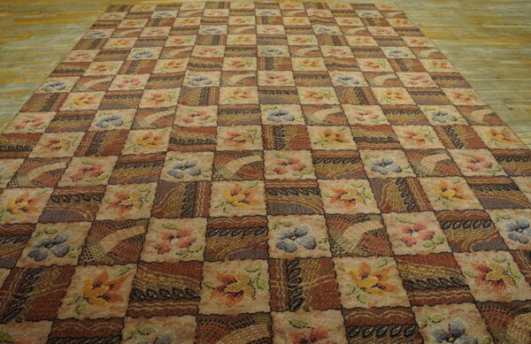 Earth-toned checkered rug featuring floral and abstract blocks lies on a light wooden floor.