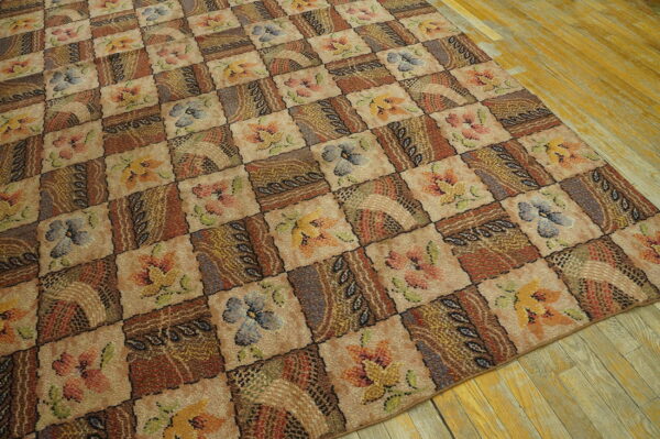 Brown and beige patchwork rug with multicolored floral designs laid over distressed wood planks.