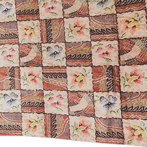 Muted patchwork rug with alternating squares of abstract designs and multicolored floral motifs.