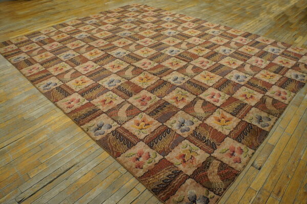 Tan and brown checkerboard rug featuring floral and abstract blocks resting on worn wooden floorboards.