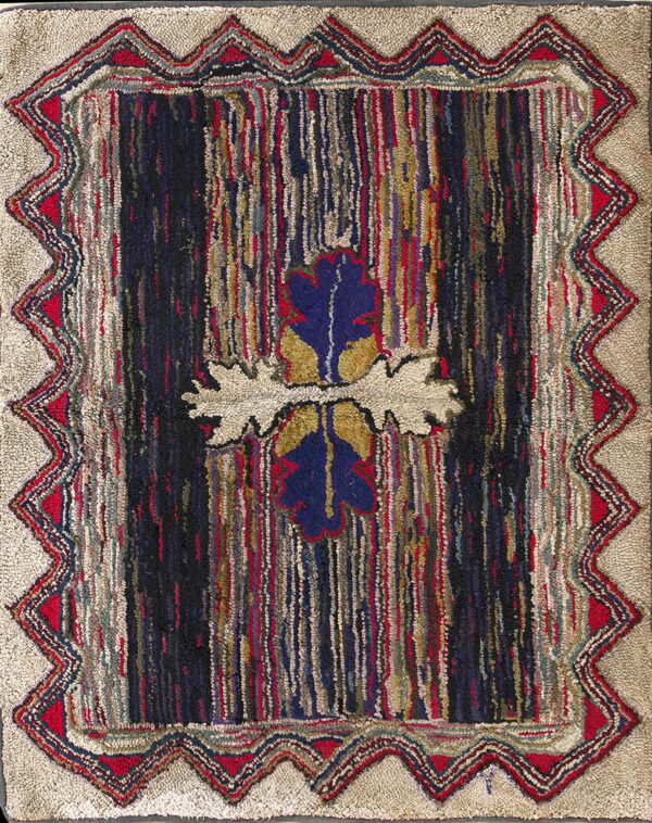 Textured rug featuring a striped dark center with a blue motif, framed by a zigzag border on a beige ground.