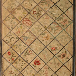 Tan and green textured rug with a dark diamond lattice overlaying faded floral motifs.