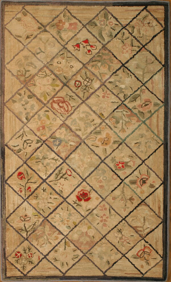 Tan and green textured rug with a dark diamond lattice overlaying faded floral motifs.