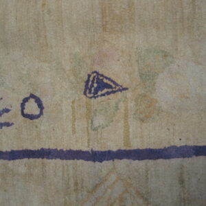 Textured beige rug detail with purple abstract elements, a horizontal stripe, and faint patches of green and pink.