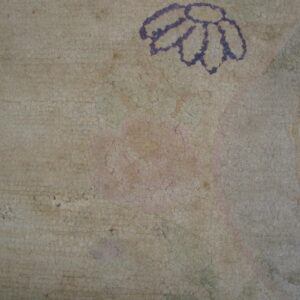 Distressed, crackled texture on a pale rug showing a faded purple daisy outline and pink remnants.