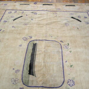 Low-pile beige rug with abstract purple and gray designs, framed by a lavender border on wood floors.