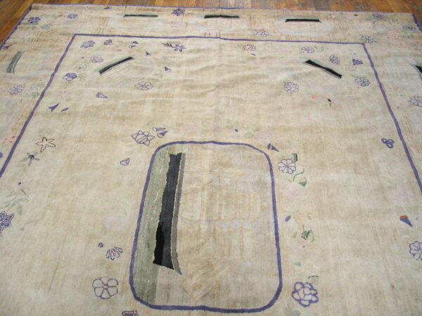 Low-pile beige rug with abstract purple and gray designs, framed by a lavender border on wood floors.