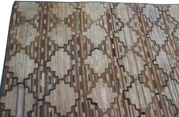 Muted brown, beige, and blue stripes form geometric diamond patterns with stepped, dark outlines on this rug.