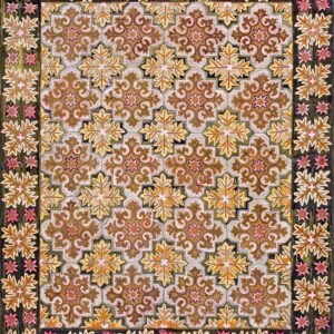 Brown, gold, and olive rug featuring a scrolling quatrefoil pattern and a dark border with pink accents.