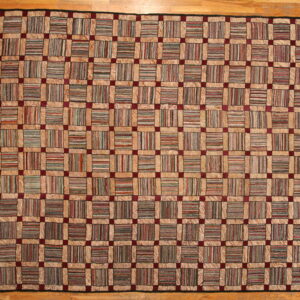 High-pile, checkerboard rug with multicolor striped squares framed by tan borders and burgundy accents.