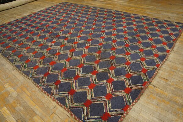 A textured square rug with blue-gray lattice and red geometric accents rests on a distressed wood floor.