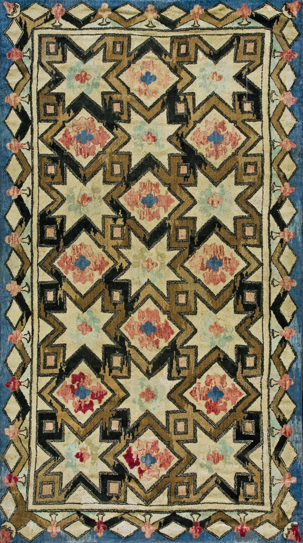 A high-pile rug displaying geometric stars and diamonds in cream, brown, black, dusty red, and blue.