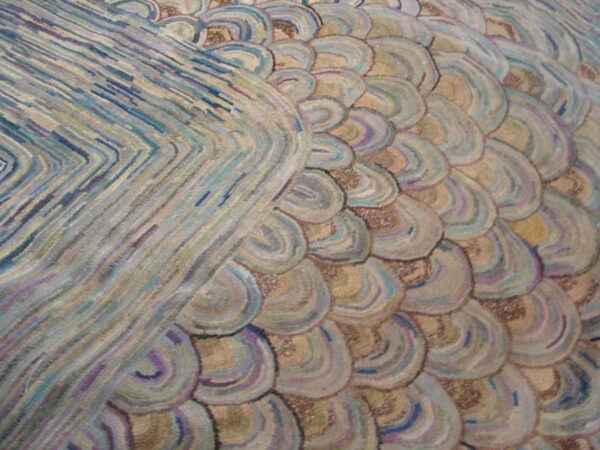 Muted pastel rug detail features a raised texture with blue chevron stripes and overlapping beige and purple scalloped shapes.